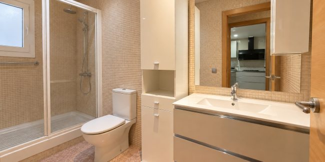 Baño moderno beige con ducha y espejo