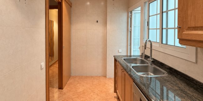 Cocina estrecha moderna con fregadero y ventanales