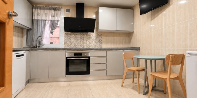 Cocina moderna con comedor y TV
