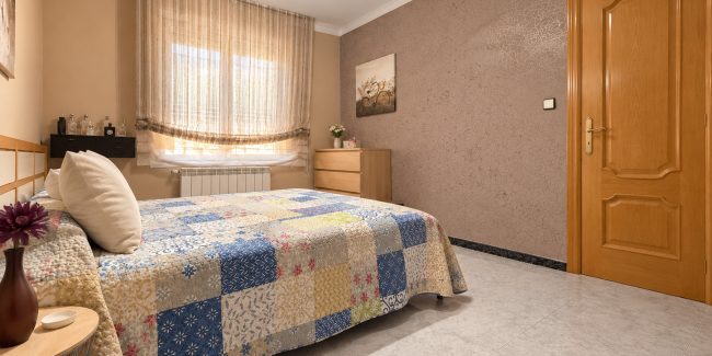 Dormitorio acogedor con cama colorida y luz cálida