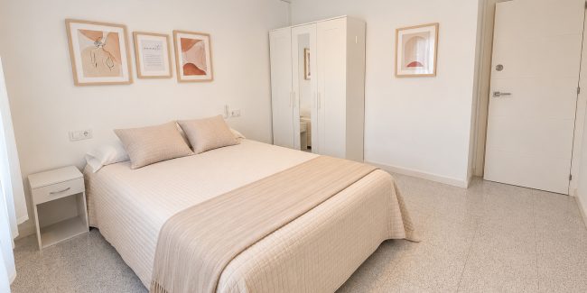 Dormitorio beige minimalista con arte y armario