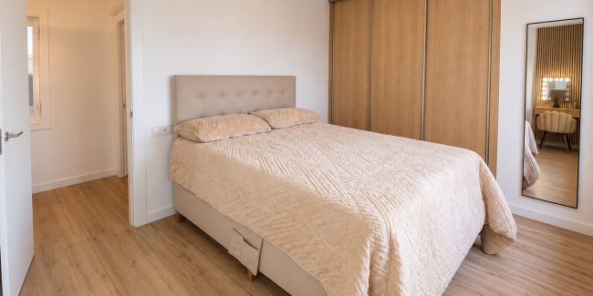 Dormitorio escandinavo con armario de madera y espejo