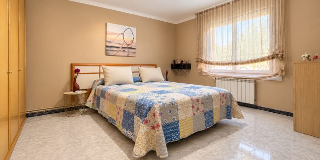 Dormitorio luminoso con colcha de patchwork