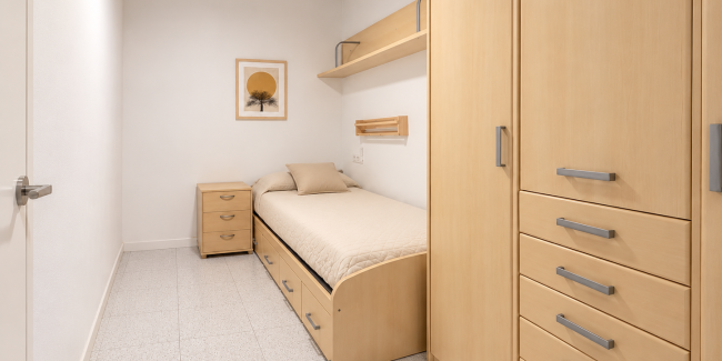 Dormitorio minimalista con cama y armario de madera clara