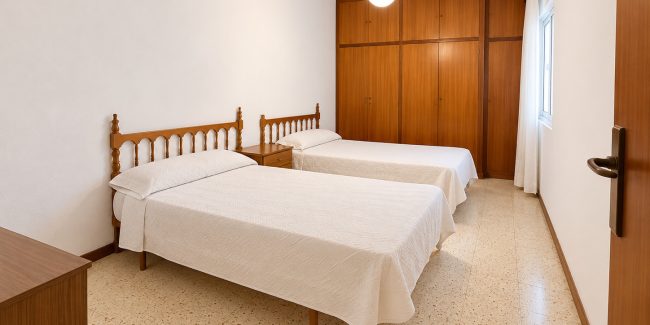 Dormitorio minimalista con camas gemelas y madera cálida