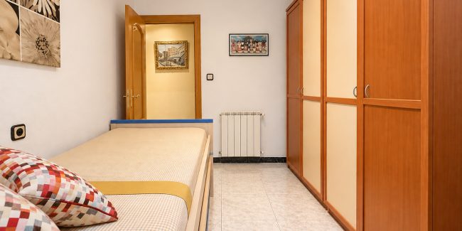Dormitorio minimalista con puerta abierta