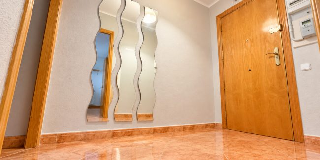 Entrada moderna con suelo brillante y espejos ondulados