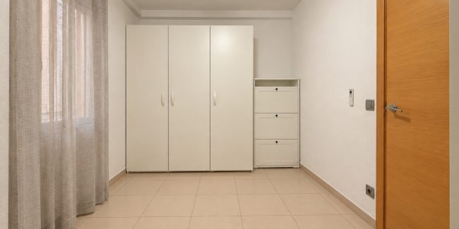 Habitación minimalista con armarios blancos