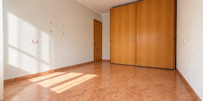 Habitación vacía con armario de madera y luz cálida