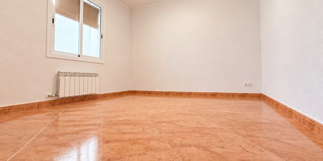 Habitación vacía con suelo brillante y ventana