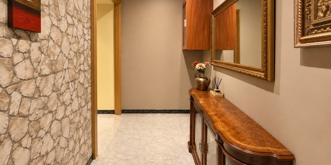 Pasillo cálido con consola y espejo dorado