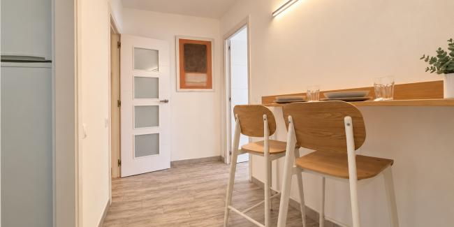 Pasillo minimalista con barra y taburetes