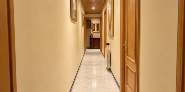 Pasillo residencial cálido con espejo dorado