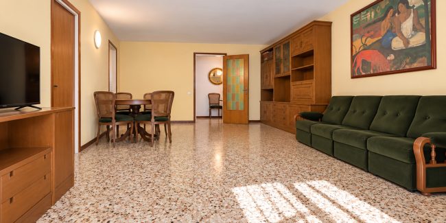 Salón retro con sofá verde y suelos de terrazo