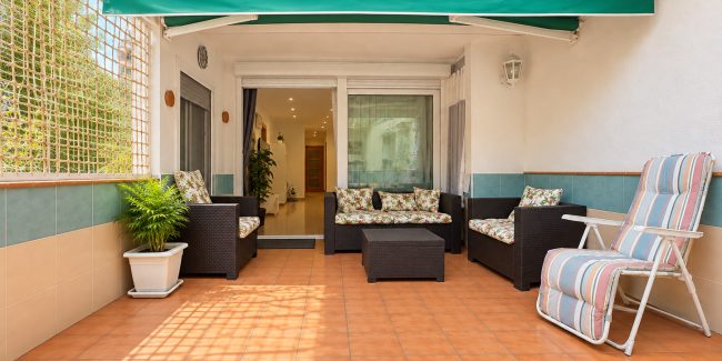 Terraza mediterránea con mobiliario de mimbre