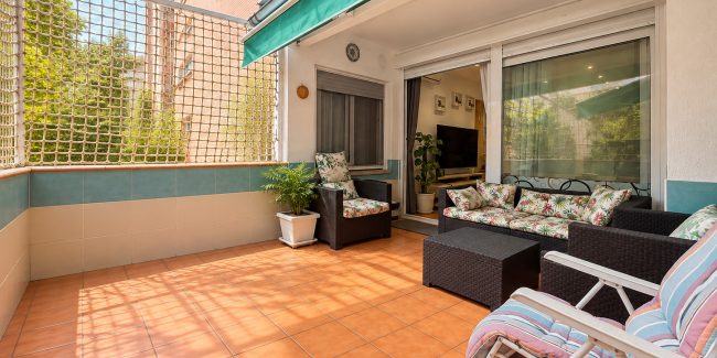 Terraza soleada con mobiliario de mimbre